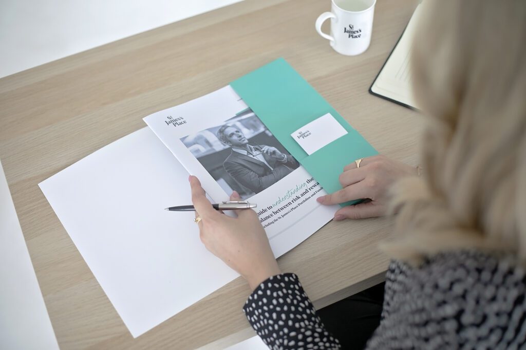 St James Place leaflet being opened by Financial adviser used as a prop for her branding photoshoot