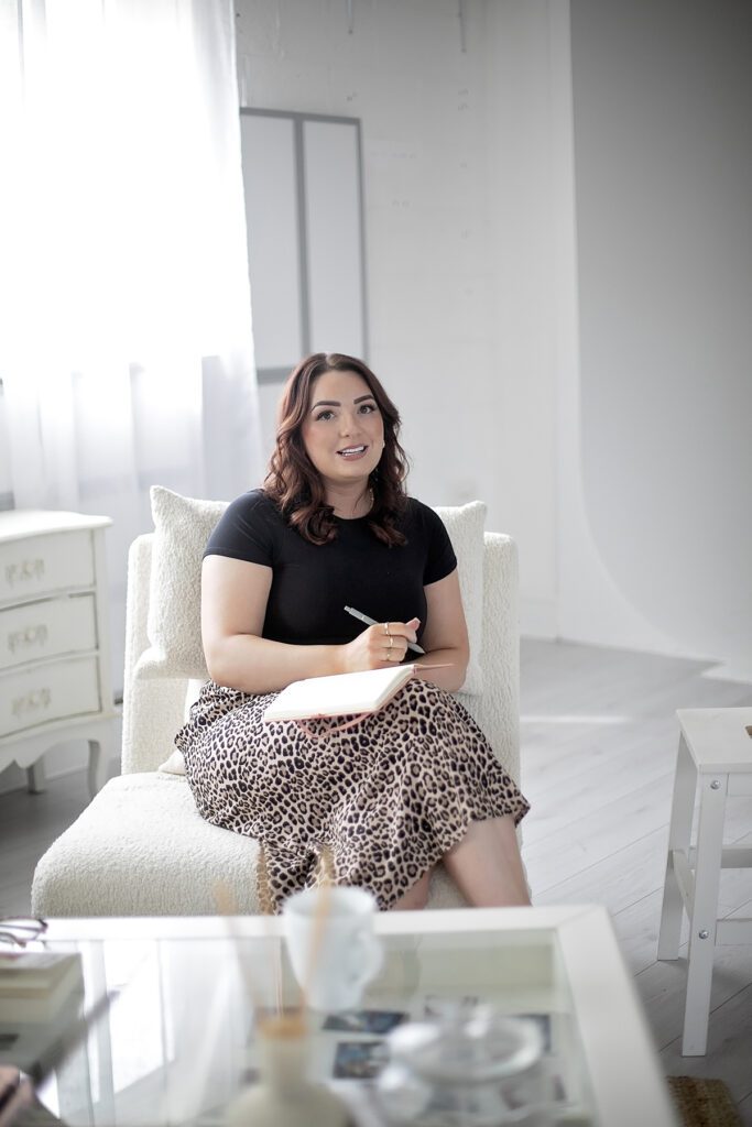Female business owner writing in notebook with leopard print skirt
