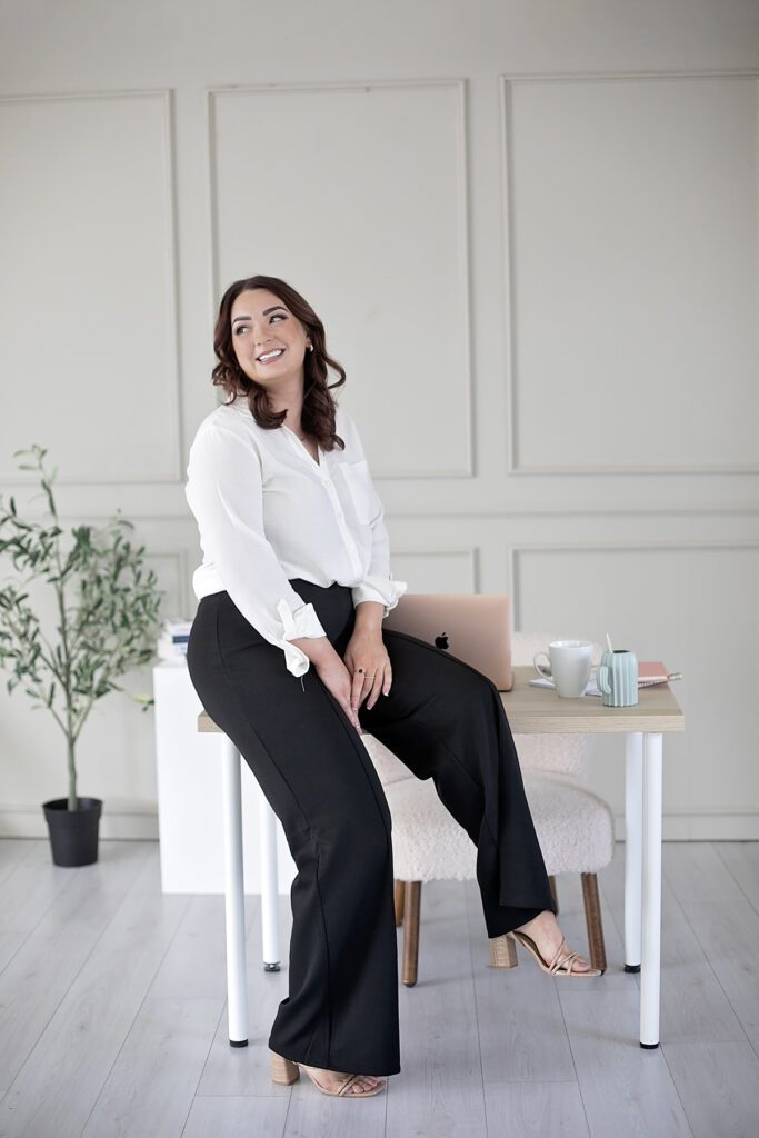 smart business woman sat on side of desk