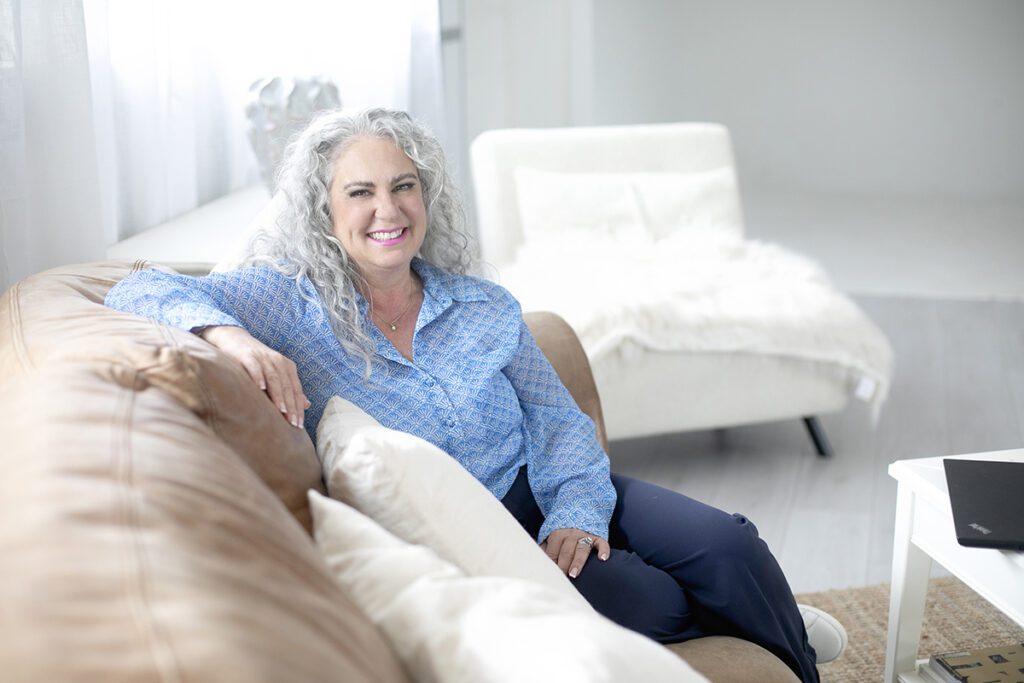 Business coach sat on sofa in blue shirt